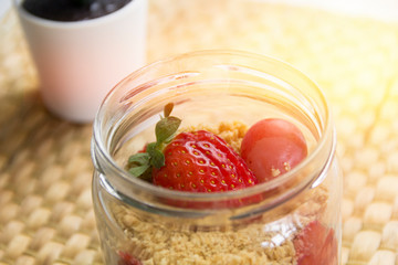 Succulent flowers and mascarpone dessert with crushed vanilla biscuits, strawberry in a glass jar