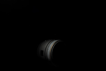 Underexposed photo of DSLR camera lens. Stock photo isolated on black background. Low light photo and large depth of field.