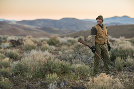 Chukar hunter standing with gun, Nevada, USA