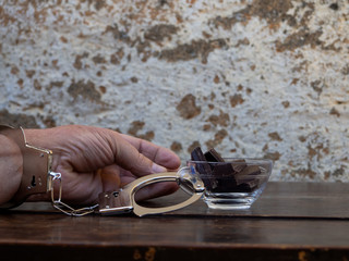 A man handcuffed to a cup with chocolate. Food or chocolate addiction concept