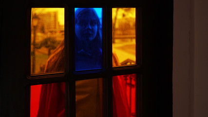 beautiful girl opens the door with colored glass