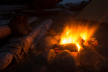 Boots drying near burning campfire at night