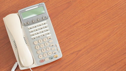 old office telephone on the desk for business communication, multi language retro interior 1990...