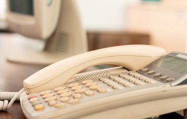 closeup old office telephone on the desk for business communication, multi language retro interior...