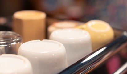 group of cups on coffee maker in cafe, white clean ceramic shelf