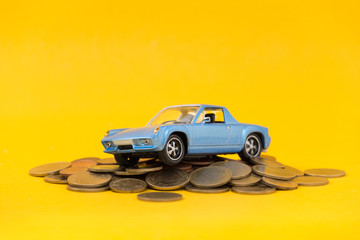 Classic of model blue toy car park on stack golden coins. Saving, Financial and Installment payment concept.