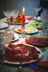 Festive set table with appetizer food and red candle