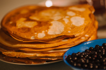 A stack of thin Russian hot pancakes blini  with currants. Shrovetide Maslenitsa - traditional...