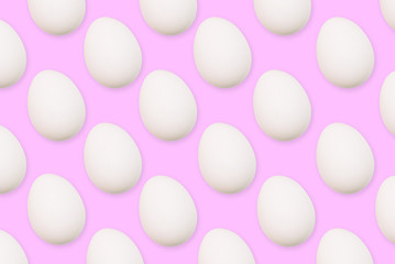 White eggs on a pink background. The flat position of the eggs arranged in a row. Festive background or greeting card