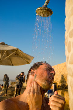Man taking outdoor shower, Dead Sea, Madaba Governorate, Jordan