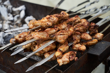 Roasted chicken wings meat kebab on skewers, close-up