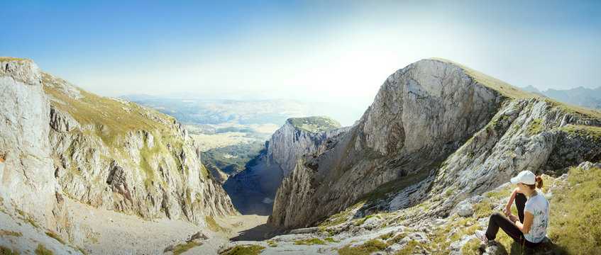 Young woman sitting in eroded mountains