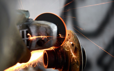 car mechanic working with angular grinding machine, metal sparks