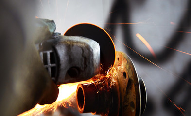 car mechanic working with angular grinding machine, metal sparks