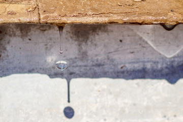 Close-up spring drops on the street in a large macro increase in the sunlight day. Soft and selective focus.