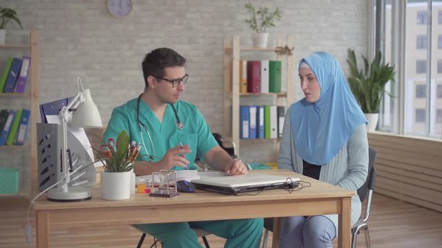Young muslim woman in hijab at a doctor's appointment men