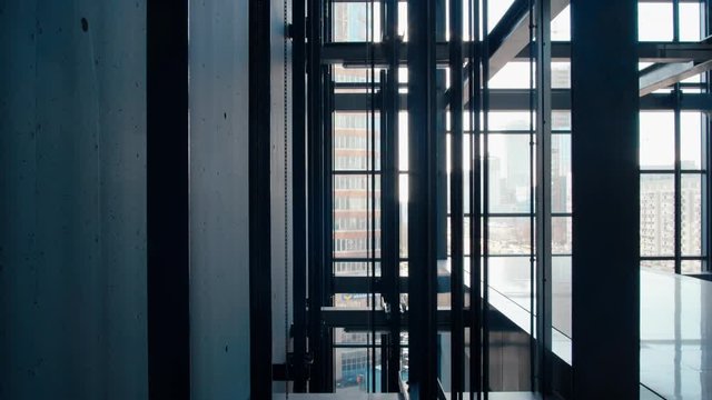 Moving Elevators With People inside in Modern Office Business Building Going Up and Down in Transparent Glass Lift Shaft in Skyscraper or Shopping Mall