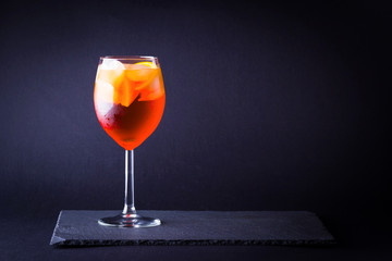 Cocktail aperol spritz on dark background. Summer alcohol cocktail with orange fruit in minimalism style. Italian cocktail aperol spritz on slate board