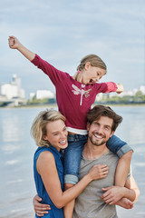 Germany, Duesseldorf, happy family with daughter at Rhine riverbank