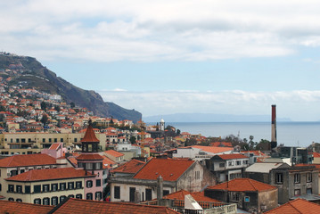 a panoramic rooftop view of the old town in funchal madeira with the sea and mountains in the...