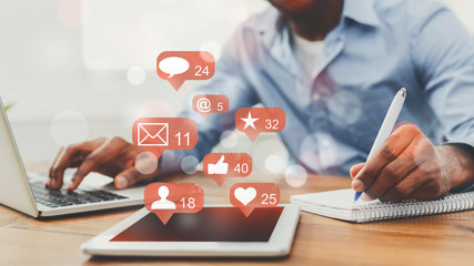 Social media notifications. Man working on laptop
