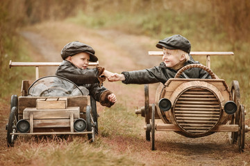 Portrait of two boys on improvised racers cars