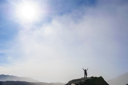 Indonesia, Java, Bromo Tengger Semeru National Park, Woman standing in backlight on the edge of Mount Bromo crater