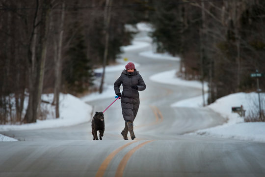 Woman walking with dog in winter