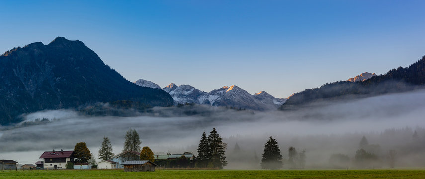 Germany, Bavaria, Upper Allgaeu, Loretto meadows near Oberstdorf with morning fog and mountains in background
