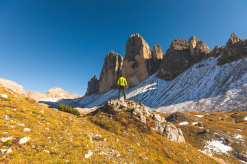 Italy, Tre Cime di Lavaredo, man hiking and standing in front of the majestic three peaks