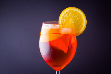 Cocktail aperol spritz on dark background. Summer alcohol cocktail with orange slices. Italian cocktail aperol spritz on slate board. Trendy beverage