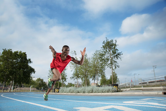 Male athlete sprinting on all-weather running track, Barcelona, Spain