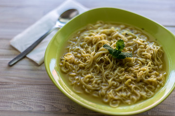 Simple Noodles Soup on a Green Plate With Mint