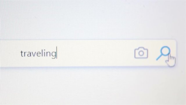 Internet user writes the word traveling in the search bar.Browser search bar.