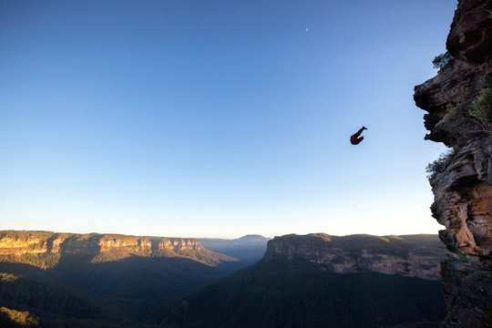 Silhouette of BASE jumper against clear sky, New South Wales, Australia