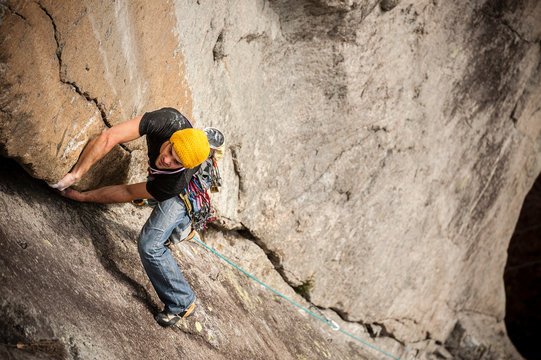 Man lead climbing a two pitches crack route in trad style  (that means that only self-placed gear like friends and nuts is allowed for protect the ascent) in Cadarese, Ossola Valley, Italy.