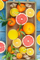 Set of different fruits and glass with fresh orange juice, wooden tray
