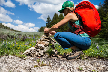 A woman builds a pile of rock to mark the trail. Ten Sleep, Wyoming.