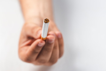 close-up of a man hand offering a cigarette on white background