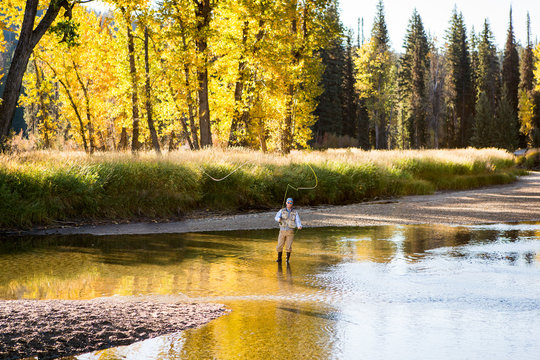 Man fishing in river on sunny day