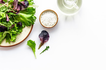 organic food pattern with green and red salads mix and oil white background top view space for text