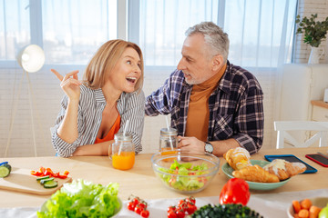 Mature couple eating healthy garden salad and drinking juice