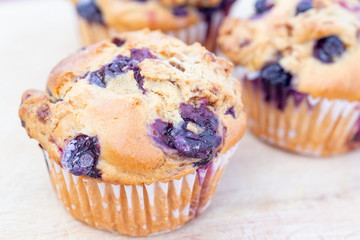 Homemade vegan blueberry muffin presented on a wooden plate