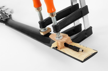 Guitar repair and service - Clamping a guitar neck closeup white