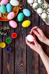 Colorful eggs for easter on wooden background top view