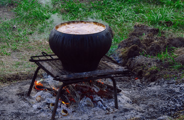 cooking on a campfire in nature in a chavun made of cast iron
