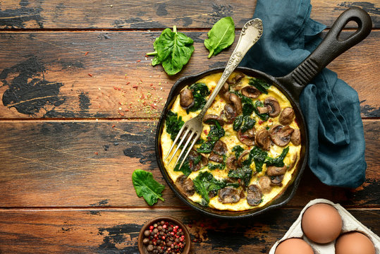Omelette with mushrooms and spinach in a cast iron pan.Top view with copy space.