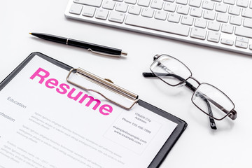Create CV concept with pen, glasses, keyboard on white desk top view