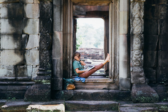 Girl is sitting in ancient ruins