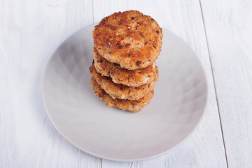 cutlets on a grey plate, on a white wooden background